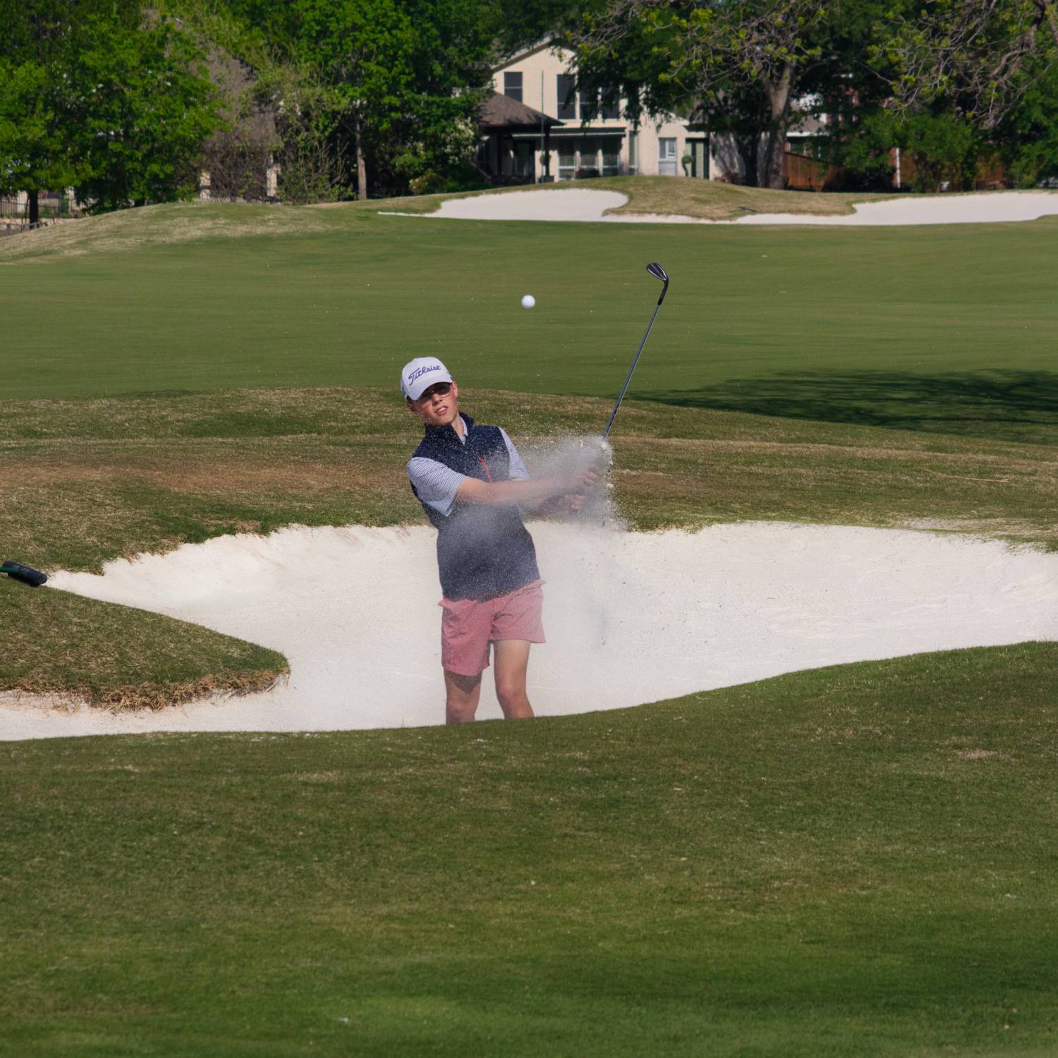 A golfer practicing from the bunker